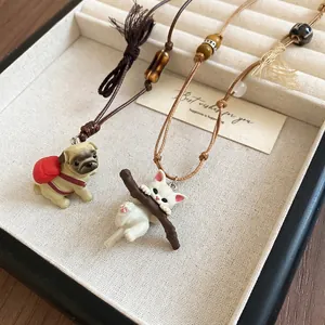 Handcrafted wax rope necklace featuring cute ceramic cat and dog charms with wooden beads