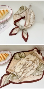 Detail of pleated silk scarf with vintage rose print and contrasting red borders