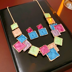 Macro shot of colorful square oil-drop enamel necklace and earrings jewelry set on black leather