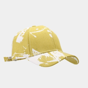 Detail view of mustard yellow tie-dye baseball cap with adjustable metal buckle strap