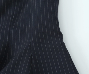 Macro detail of navy blue and white pinstripe fabric texture and stitching on slim top