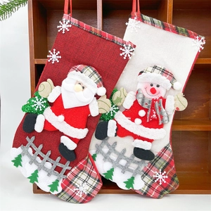 Close-up of linen Christmas stockings with Santa and Snowman 3D plush appliques