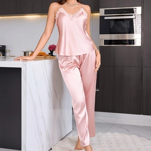 Elegant pink satin pajama set with lace camisole and long pants for home lounging