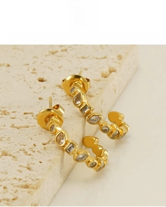 Detail of 18K gold plated U-shaped earrings with marquise and square zircon stones