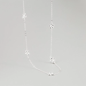 Close-up of minimalist S925 sterling silver chain with five sweet daisy flower charms
