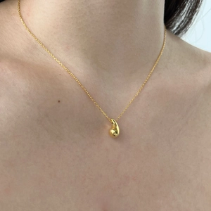 Close-up of minimalist 925 silver water drop pendant in polished gold on person neck