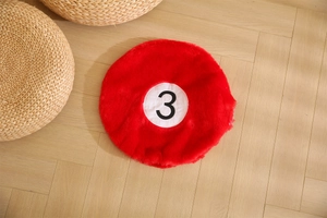 Detail of red number 3 billiard ball plush rug on a warm herringbone wood floor