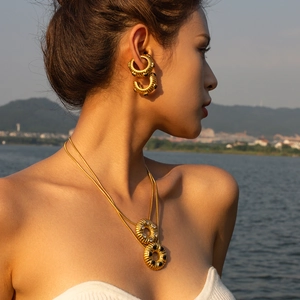 Golden bread-textured C-shaped earrings and zircon necklaces in sunset beach light