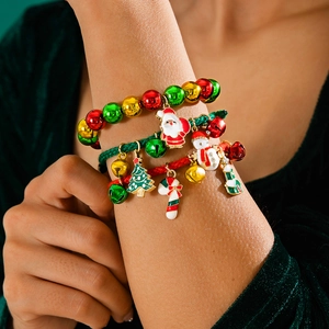 Detailed view of Christmas red cord bracelet with Santa and snowman enamel charms on wrist
