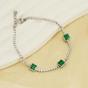 Detail of silver tennis bracelet with green square zircons and lobster clasp closure