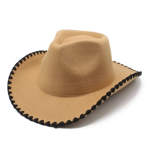Detail of khaki cowboy hat featuring black leather braided trim on the curved brim