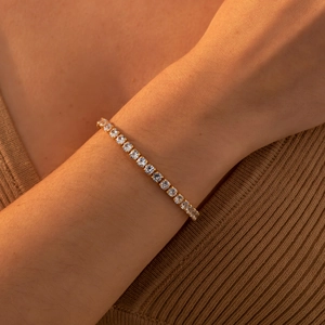 Close-up of gold plated tennis bracelet with square zircons on model's wrist