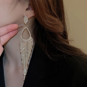 Detail of luxury gold tassel earrings with rhinestone water drop design on model