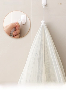Close-up of white mesh storage bag with hanging cord for kitchen vegetable storage