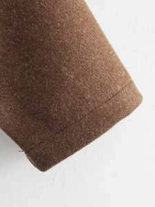 Detailed close-up of brown wool jacket cuffs showing high-quality stitching and fabric texture