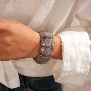 Nahaufnahme des breiten Stretch-Armbands mit grauen Glitzer-Acryl-Segmenten