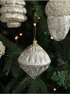 Dettaglio di ornamenti natalizi color oro champagne con perline e gemme preziose