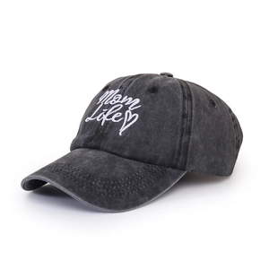 Close-up of Mom Life embroidery on a washed dark gray cotton baseball cap texture
