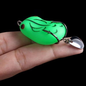 Detailed close-up of a green frog lure with sharp hooks and a rotating silver sequin