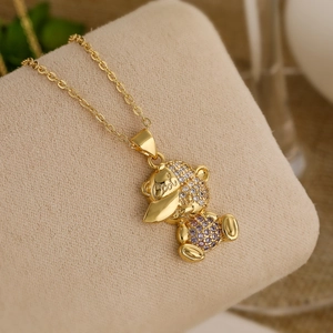 Gold plated bear pendant necklace with sparkling clear zircons and purple gemstones