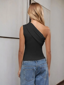 Rear view of a slim black one-shoulder top paired with blue jeans against a grey wall