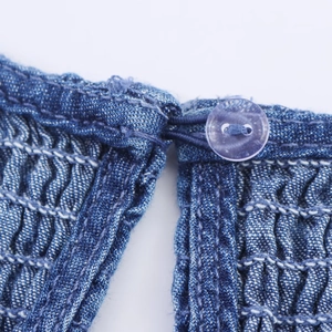 Blue denim style short dress with textured smocking fabric and clear button detail