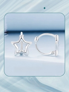 Macro shot of S925 sterling silver hollow star hoop earrings on a blue marble stand