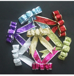 Close-up of glittery Christmas tree bows in mixed colors like gold and red for festive decor