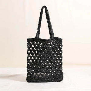 Fashionable black hollow woven straw bag with long handles for casual beach vacation style