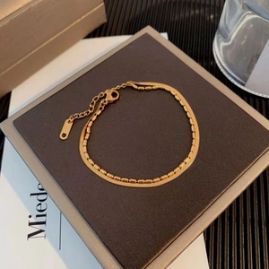 Double layer gold titanium steel bracelet featuring snake bone and bead chain on a box