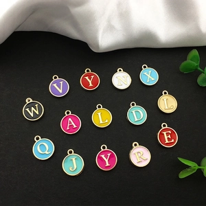 Detailed macro view of colorful enamel alphabet charms with gold alloy frame on black background