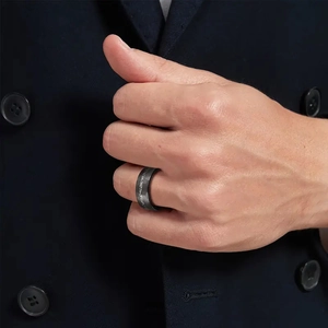 Matte charcoal tungsten ring for men featuring textured brushed surface on hand