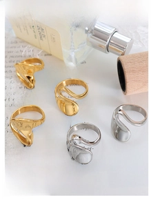 Detailed view of irregular organic curved rings in polished gold and silver finishes