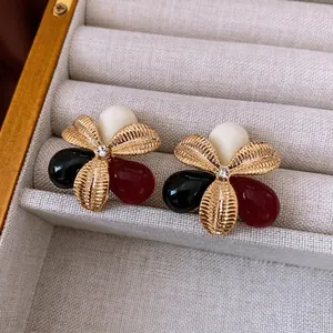 Vintage gold petal earrings with resin inlay and zircon center in jewelry display box