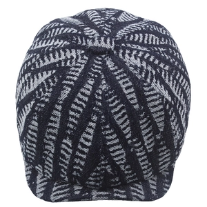 Detail of black and white leaf-patterned woven texture on a vintage newsboy cap