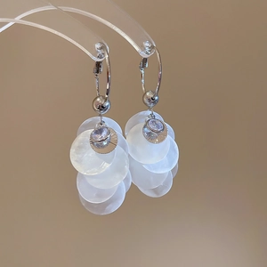 Détail des boucles d'oreilles pampilles en argent avec coquillages blancs et petits zircons