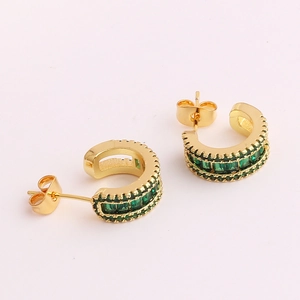 Detail of C-shaped gold earrings set with two rows of radiant green square gemstones