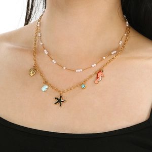 Double-layered gold necklace with sea horse, starfish, shell and pearl ocean charms