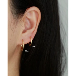 Close-up of gold hoop earrings on model ears showing 10mm and 12mm size options