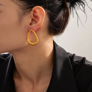 Chic gold-plated titanium steel twist hoop earrings worn by a model in a side view