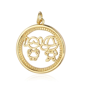 Macro shot of a gold-plated round pendant with cutout boy and girl figures