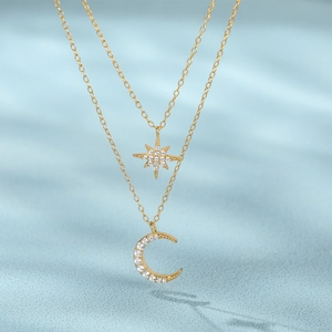 Close-up of double-layer gold necklace with star and moon pendants in sparkling zircon