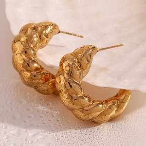 Detailed close-up of 18K gold plated hollow crescent earrings with dew drops on a shell