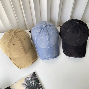 Detailed view of washed cotton baseball caps with vintage distressed brim and metal eyelets