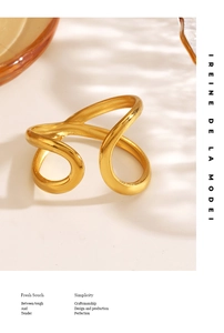 Dettaglio di un anello aperto dorato dal design minimalista a linee irregolari