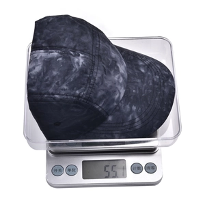 Vue détaillée d'une casquette 5 panneaux à motif marbré de 55g sur une balance digitale