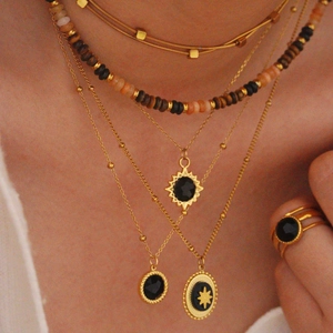 Layered gold 14K stainless steel necklace with black onyx pendant and sunburst charm