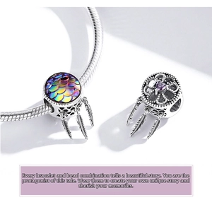 Macro detail of S925 sterling silver dreamcatcher charms with colorful fish scales and feathers