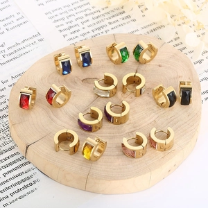 Macro shot of minimalist gold stainless steel earrings with colorful zircon stones