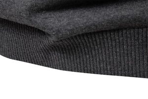 Close-up of high-quality dark grey ribbed cuffs and hem texture on men's knit sweater